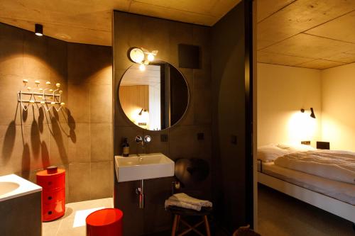 a bathroom with a sink and a bed and a mirror at Stud!o 8 in Bezau