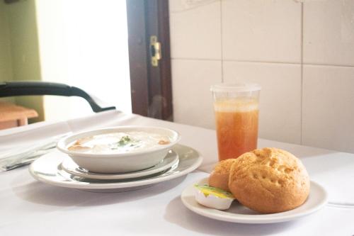 a bowl of soup and a sandwich and a drink on a table at Hotel Dinastia Real in Duitama