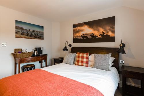 a bedroom with a bed and a desk in it at The Queen's Arms in Hungerford