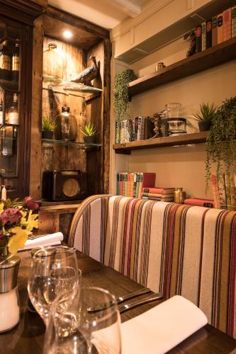 a restaurant with a table and chairs with wine glasses at The Queen's Arms in Hungerford