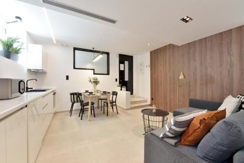 ein Wohnzimmer und eine Küche mit einem Sofa und einem Tisch in der Unterkunft Phaedrus Living City Center Luxury Flat Skoufa in Athen