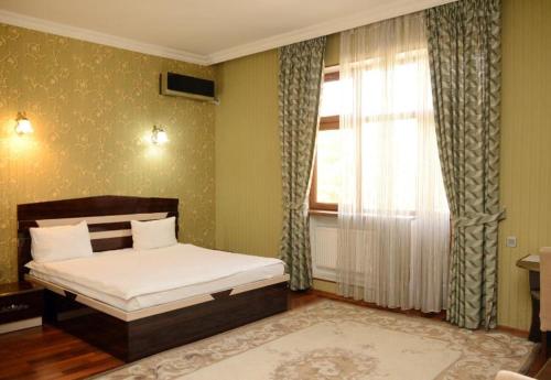 1 dormitorio con cama y ventana en HII Hotel, en Sheki