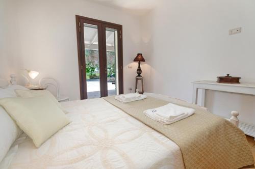 a white bedroom with a bed and a fireplace at Villa Marzoni con Piscina Privata by HDSalento in Tiggiano
