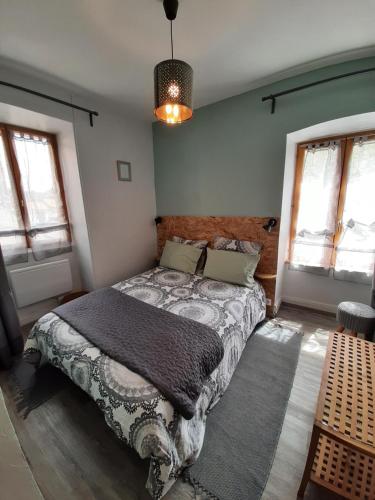 Gîte la maison de Mika في Saint-Floret: غرفة نوم مع سرير في غرفة مع نوافذ