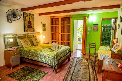 a bedroom with a bed in a room with green walls at Budha by Majikal B&B in Mérida