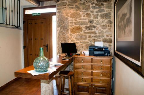 a room with a desk with a computer on top of it at A Casa do Folgo Turismo Rural in Negreira