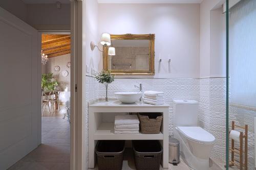 a bathroom with a sink and a toilet and a mirror at Casa Portolago in Carballo