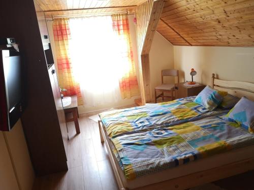 een slaapkamer met een bed in een kamer met een raam bij Szabó Vendégház in Siklós