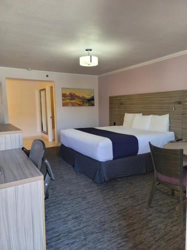 una camera d'albergo con un grande letto e una scrivania di Death Valley Inn & RV Park a Beatty