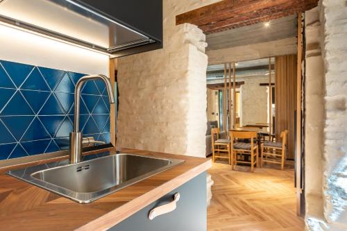 a kitchen with a sink and a dining room at Santa Clara Suites Sevilla in Seville