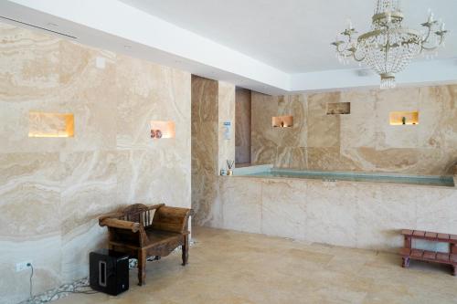 Pokój z krzesłem i lustrem na ścianie w obiekcie Huge Golf and Spa Mansion 8 min from Puerto Banus w mieście Estepona