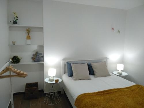 ein Schlafzimmer mit einem Bett mit zwei Lampen auf zwei Tischen in der Unterkunft Apartamentos Areia e Mar Norte in Vila Praia de Âncora
