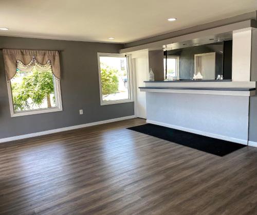 an empty living room with wood floors and windows at Budget Inn New Cumberland-Harrisburg-Hershey-York in New Cumberland