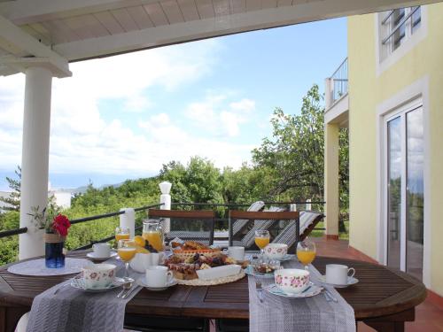 einen Holztisch mit Speisen und Getränken auf dem Balkon in der Unterkunft Holiday Home with Sea View in Vrbnik