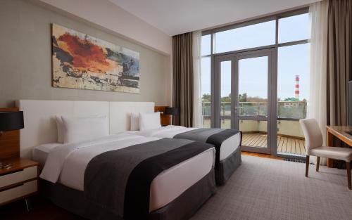 ゲレンジークにあるMetropol Grand Hotel Gelendzhikのベッド2台と大きな窓が備わるホテルルームです。