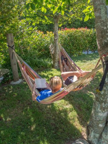 two children laying in a hammock with a book at Anakiwa 401 in Anakiwa