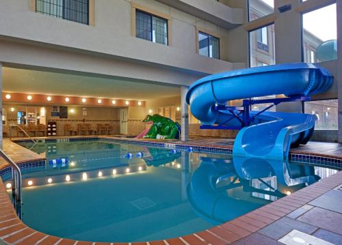 a large pool with a water slide in a hotel at Holiday Inn Express Hotel & Suites Longmont by IHG in Longmont