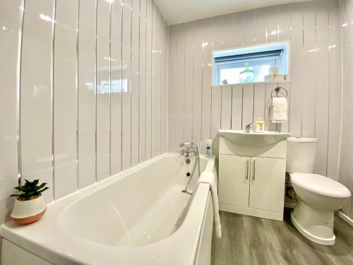 La salle de bains blanche est pourvue d'une baignoire et de toilettes. dans l'établissement Warley House 4 Bed -Blackpool North -Family House, à Blackpool