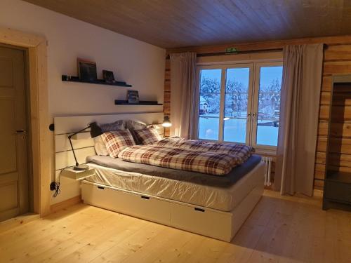 a bedroom with a bed and a large window at Timmerhus Örnen in Sorsele