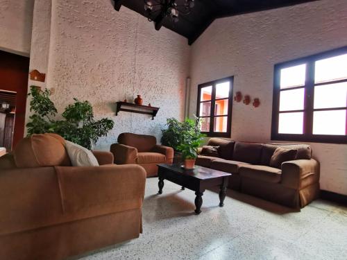 ein Wohnzimmer mit Sofas und einem Couchtisch in der Unterkunft Hotel Posada San Pedro in Antigua Guatemala