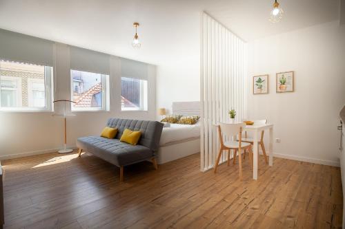 a living room with a couch and a bed and a table at Carpe Diem by Home Sweet Home Aveiro in Aveiro