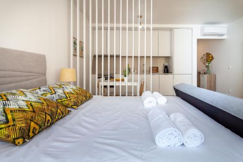 ein großes weißes Bett mit Handtüchern auf dem Zimmer in der Unterkunft Carpe Diem by Home Sweet Home Aveiro in Aveiro