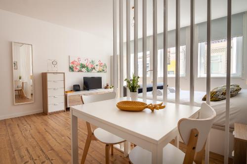 a white room with a table and chairs and a bedroom at Carpe Diem by Home Sweet Home Aveiro in Aveiro