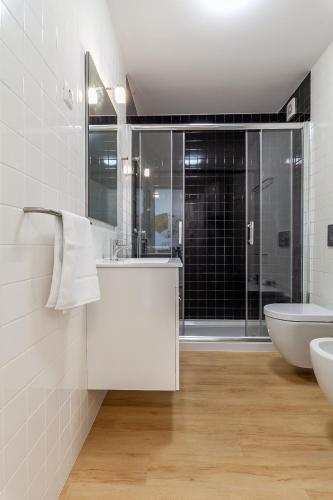 a white bathroom with a sink and a toilet at Carpe Diem by Home Sweet Home Aveiro in Aveiro