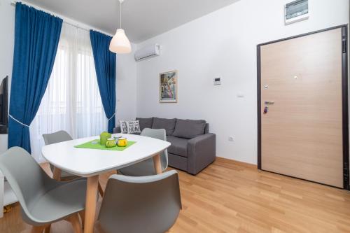 uma sala de estar com uma mesa e cadeiras e um sofá em Ana`s apartment Budva MNE em Budva