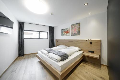 a bedroom with a bed with a wooden headboard at Atelier Garni Astei in Grossarl