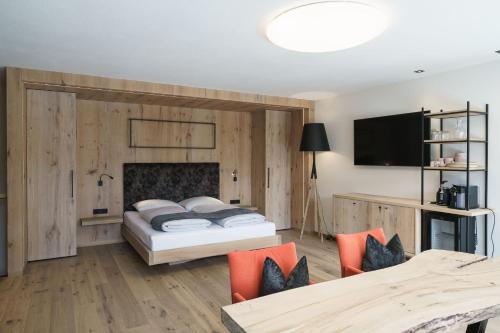 a bedroom with a bed and a tv on a wall at Atelier Garni Astei in Grossarl