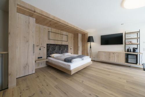a bedroom with a bed and a flat screen tv at Atelier Garni Astei in Grossarl