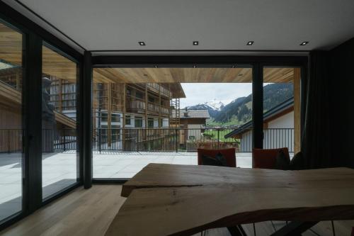 a dining room with a table and a large window at Atelier Garni Astei in Grossarl
