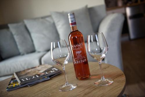 a bottle of wine and two wine glasses on a table at Tessera Villas & Studios Collection in Gouvia