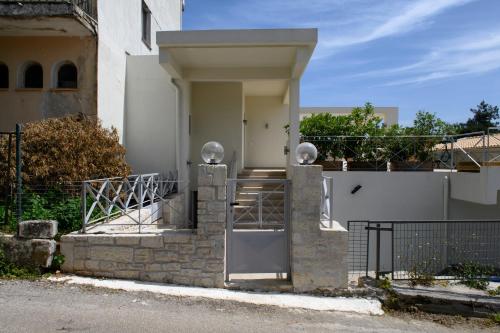 a white house with a gate and a door at Tessera Villas & Studios Collection in Gouvia