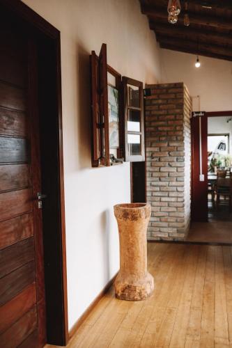 a vase sitting on the floor next to a door at Sapê Guest Hotel in Praia do Rosa