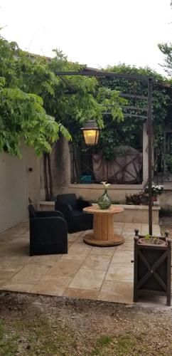 a patio with a table and a couch and a table at Calenco des Carlenes in Tarascon