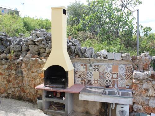 a pizza oven sitting on top of a stone wall at Holiday Home with Sea View in Vrbnik