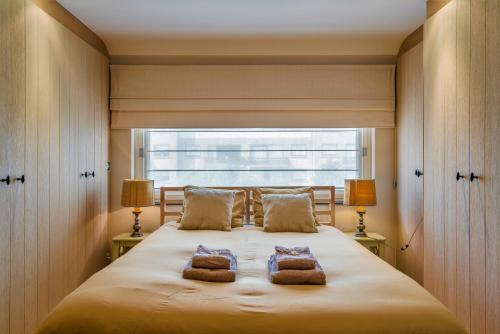 a bedroom with a large bed with two pillows on it at Huyze Clementine in Bruges
