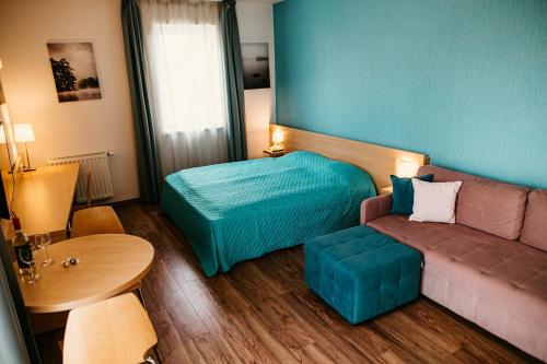 a room with a couch and a bed and a table at Tagore Spa Aparthotel in Balatonfüred