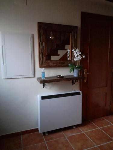 a room with a white refrigerator and a mirror at CA EFREN in Castellfort