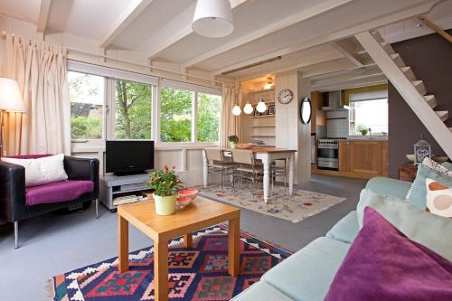 una sala de estar con un sofá y una mesa en Very nice cottage in Durgerdam, with private garden, free parking, pets allowed, en Ámsterdam