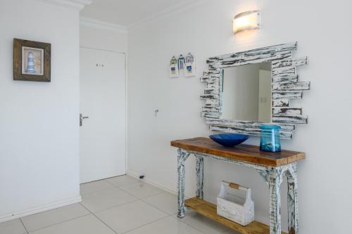 a bathroom with a table with a mirror on a wall at Chakas Cove in Ballito