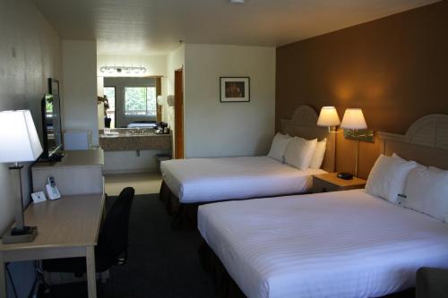 a hotel room with two beds and a desk at Lewis River Inn in Woodland
