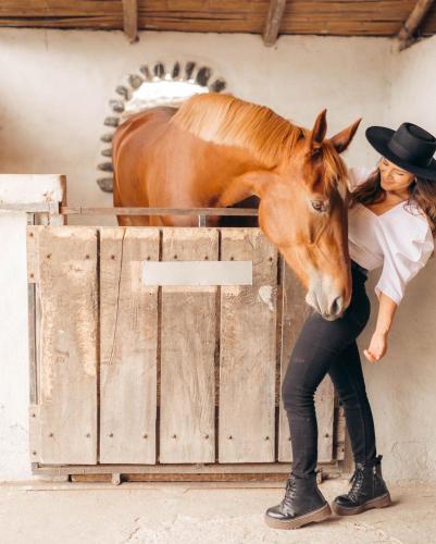a woman standing next to a brown horse at Tunas & Cabras Hotel in Ibarra