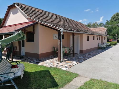 ein kleines Haus mit einer Terrasse und einem Gebäude in der Unterkunft Hacijenda MALI RAJ in Palić