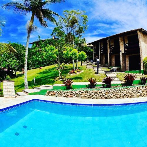 a large blue swimming pool in front of a house at Pousada Albacora in Bombinhas