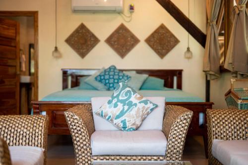 a living room with a chair and a bed at Cayena by Masaya Collection in Guachaca