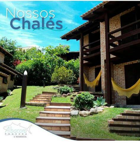 a magazine with a picture of a house with swings at Pousada Albacora in Bombinhas
