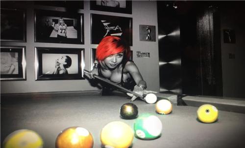 a woman with red hair playing billiard in a pool table at Bposhtels Las Vegas in Las Vegas
